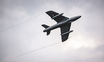 A military jet in flight against a cloudy sky, captured from below, emphasizing speed and aerodynamics. Aero L-39 Albatros jet aircraft flying through cloudy sky, showcasing sleek design and dynamic motion.