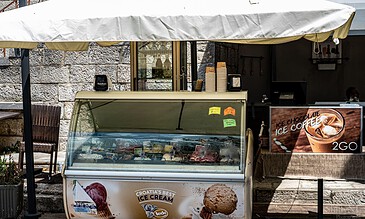 1. Ice cream and coffee stand with Croatia's best ice cream, outdoor setup with ice cream freezer and promotional signs on a sunny day.