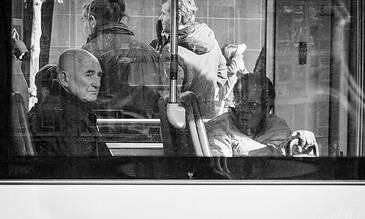 1. Reflection of diverse people on a city bus, capturing moments of daily urban life in black and white.