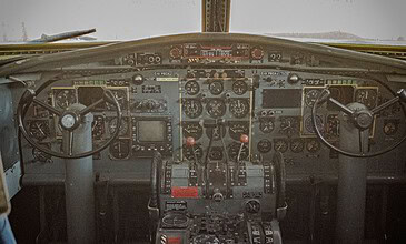 1. Interior view of an aircraft cockpit with numerous gauges, switches, and controls, showcasing aviation instrumentation and technology.