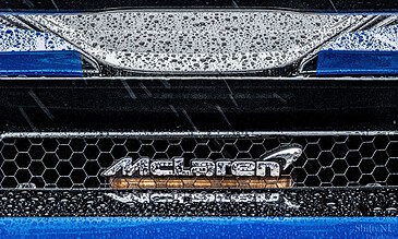 Shattered McLaren front grille with raindrops on the hood, emphasizing the sleek design and waterproof texture.