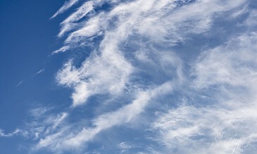 Blue sky with wispy white clouds, showcasing a serene and natural sky scene.