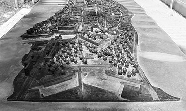A monochrome scale model of a historic city, highlighting its street network, buildings, and parks, used for urban planning or educational purposes. Detailed black and white model of a historic city layout with streets, buildings, and green spaces, showcasing architectural and urban planning features.