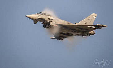 A powerful F-16 fighter jet in flight, captured during a high-speed maneuver with vapor trails against a clear blue sky. F-16 fighter jet soaring through the sky with vapor trails, showcasing military aviation and dynamic motion.