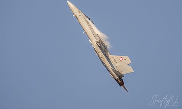 A sleek F-16 fighter jet performing a high-speed ascent against a bright blue sky, highlighting aviation photography skills. F-16 fighter jet soaring sharply through a clear blue sky during an airshow, showcasing speed and agility.