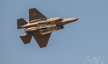 A close-up of a modern F-16 fighter jet soaring through the sky, highlighting its streamlined shape and advanced technology. F-16 fighter jet flying at high speed against a clear blue sky, showcasing sleek design and aerodynamic features.