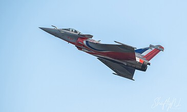 A detailed fighter jet soaring through a clear blue sky, showcasing sleek design and dynamic movement.