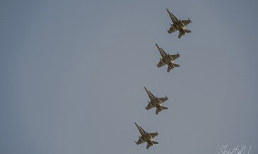 Spectacular military aircraft formation soaring through the sky, capturing the power and precision of modern fighter jets in action. Fighter jets flying in tight formation against a clear blue sky, showcasing high-speed aerial maneuvers.