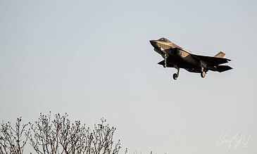 A sleek F-35 fighter jet taking off or performing a maneuver in the air, showcasing its powerful design and agility as part of an exciting aviation display. F-35 fighter jet soaring through the sky during an air show, capturing a dynamic moment with the aircraft appearing to ascend sharply with a clear blue sky in the background.
