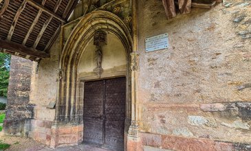 Historic church entrance featuring a carved stone archway, religious sculpture, and aged wooden door, reflecting centuries of architectural and spiritual significance. Vintage church entrance with a wooden door, ornate stone archway, and religious sculpture, showcasing historic architecture and craftsmanship.