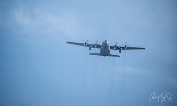 Stunning aerial shot capturing a military aircraft soaring through the bright blue sky, showcasing aviation excellence. Aerial view of a military transport airplane flying high in a clear blue sky during daytime.
