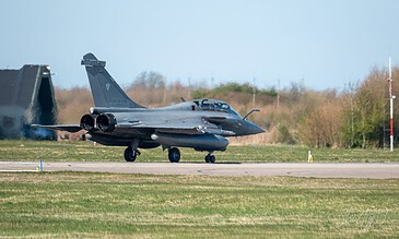 A Dassault fighter jet taking off from an airfield during daytime, showcasing aviation excellence and military power.