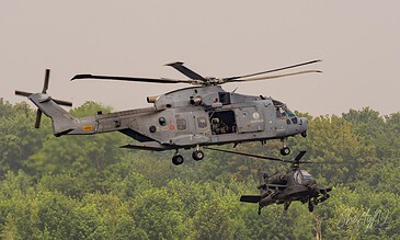 Italian Navy EH-101 2-20 flying with a Royal Netherlands Air Force AH-64D Apache below during the APROC 2018 personnel recovery exercise at Gilze-Rijen Air Base, the Netherlands, June 2018.
