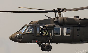 Crew member waving from the cabin window of a Swedish HKP 16 Black Hawk during the APROC 2018 personnel recovery exercise at Gilze-Rijen Air Base, the Netherlands, June 2018.