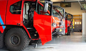 Red crash tenders ready in the fire station garage at Naval Air Station De Kooy, the Netherlands, during a visit to 860 Squadron, October 2017.
