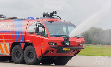 Red airport crash tender of the fire brigade spraying water at Naval Air Station De Kooy, the Netherlands, during a visit to 860 Squadron, October 2017.