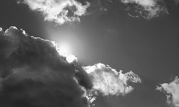 Stunning monochrome cloudscape capturing sunlight breaking through dark clouds, highlighting the power and serenity of nature's sky artwork. Vivid black and white photograph of sunlight piercing through dramatic cloud formations in the sky, showcasing natural beauty and atmospheric depth.