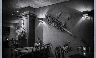 A stylish restaurant scene with modern lighting and decorative elements creating a warm, inviting atmosphere for special occasions. A cozy restaurant interior in black and white with elegant wall art, unique lighting, and tasteful decor, perfect for capturing memorable moments.
