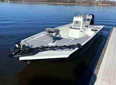 2024 Lowe Bay 22' white and grey fishing boat in lake next to a pier