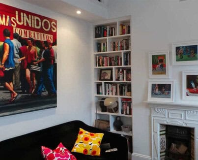 2 slim and tall White painted alcove bookcases on either side of a fireplace
