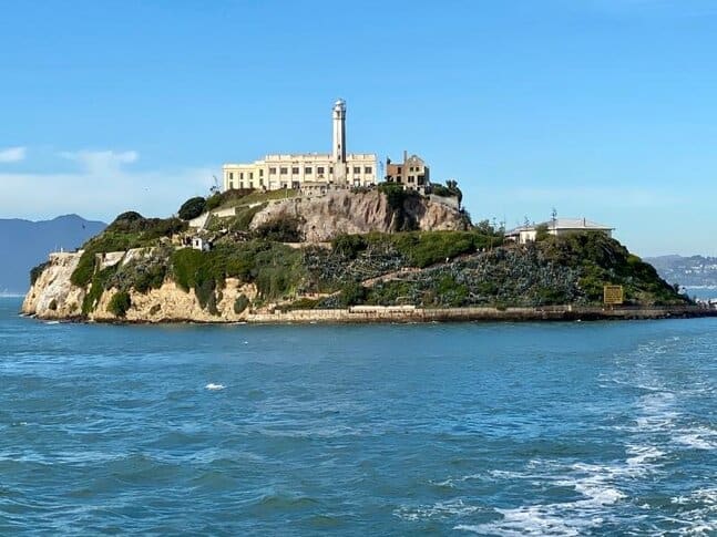 A view of the whole island of Alcatraz, shot from sea level, with the old prison visible