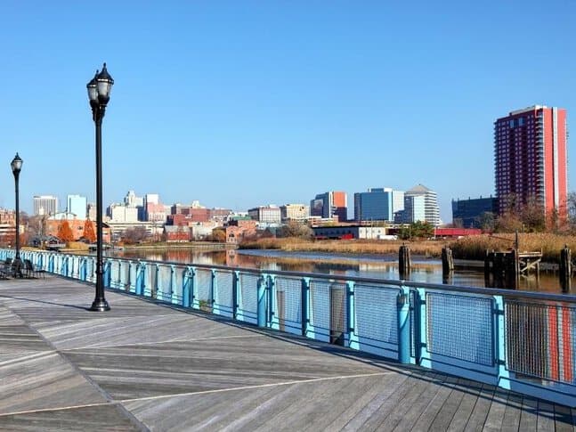 An empty boardwalk on the water with a view of Wilmington, Delaware
