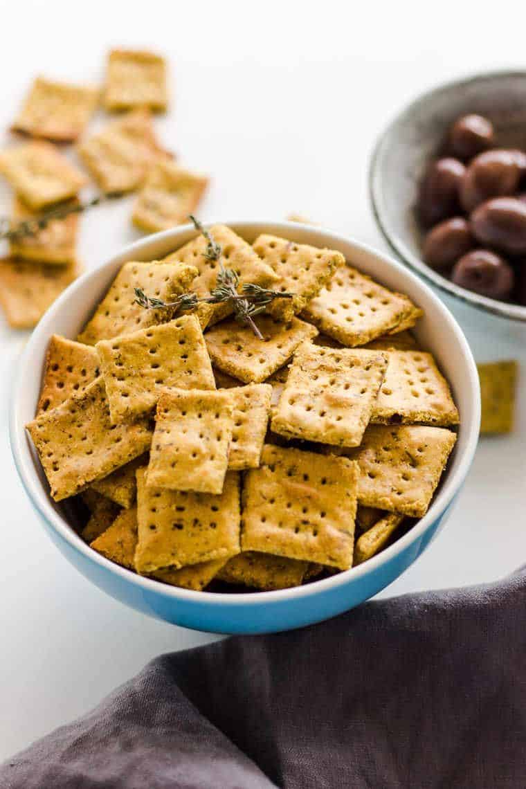 Oil Free Olive Crackers with rosemary in a blue and white bowl standing on the table