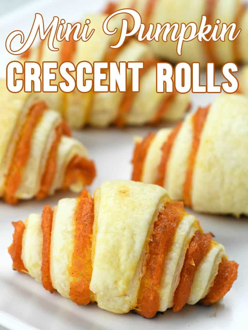 Bunch of Mini Pumpkin Crescent Rolls on parchment paper.