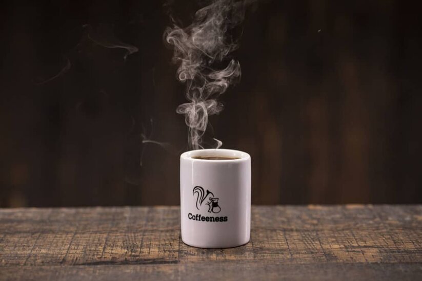Café caliente en taza corporativa de Coffeeness