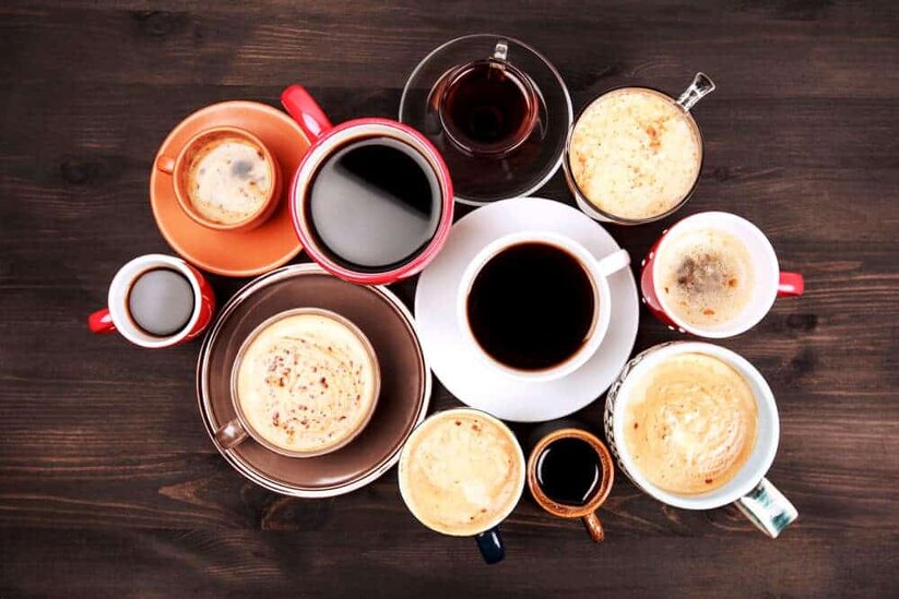 Vista desde arriba de varias tazas con bebidas de café y café con leche