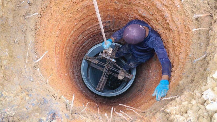 a person digs a well for groundwater after using geophysical applications