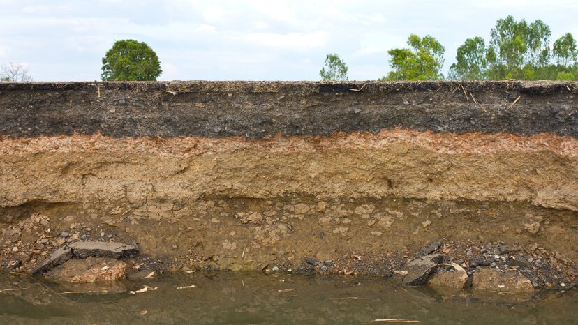 layers of soil beneath an asphalt road to illustrate how environment impacts accuracy