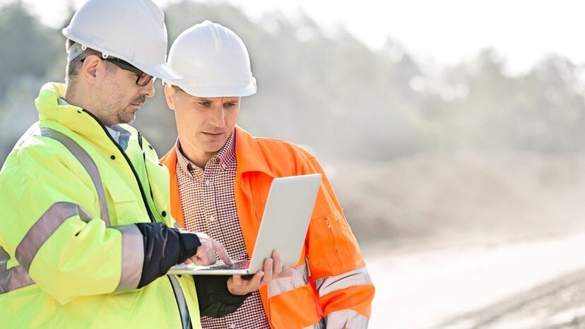 construction workers look at the ground penetrating radar antenna frequency on a laptop
