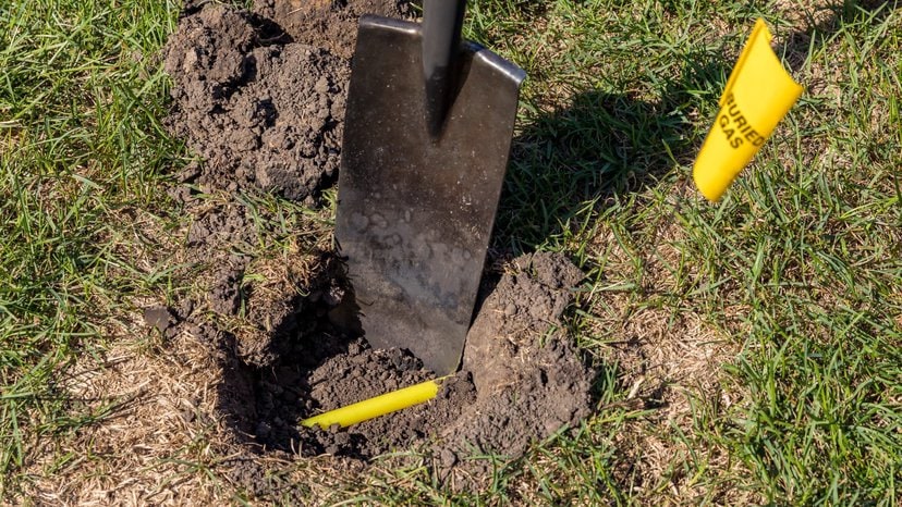 a hole in a yard with yellow plastic natural gas line buried in the ground shows a quick look at how GPR works in the field