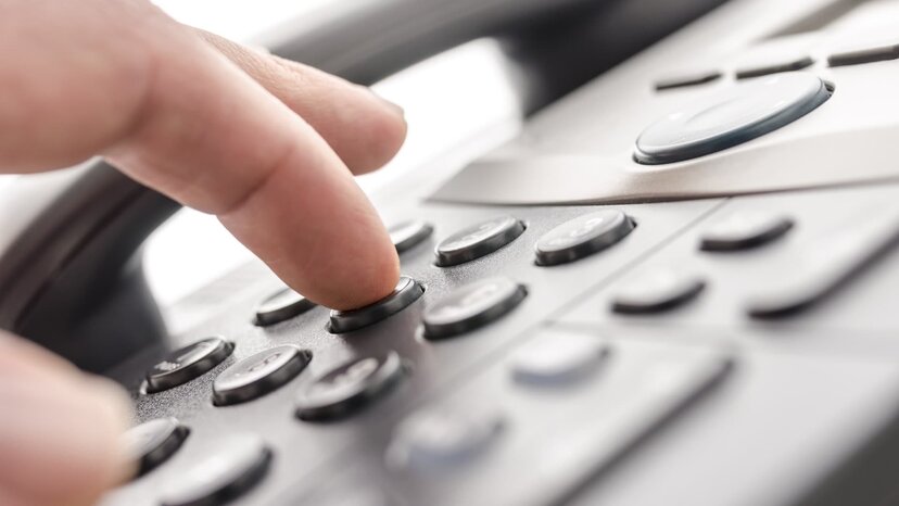 a person dials buttons on a phone