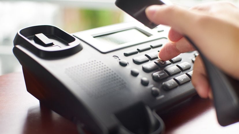 a person’s hand picks up a phone to call US Radar about getting started with ground-penetrating radar