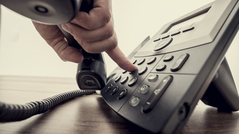 a person dials buttons on phone