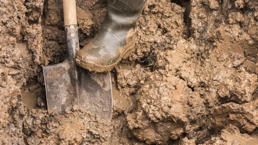 a person digs into clay with a shovel