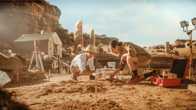 two people dig at an archaeological site