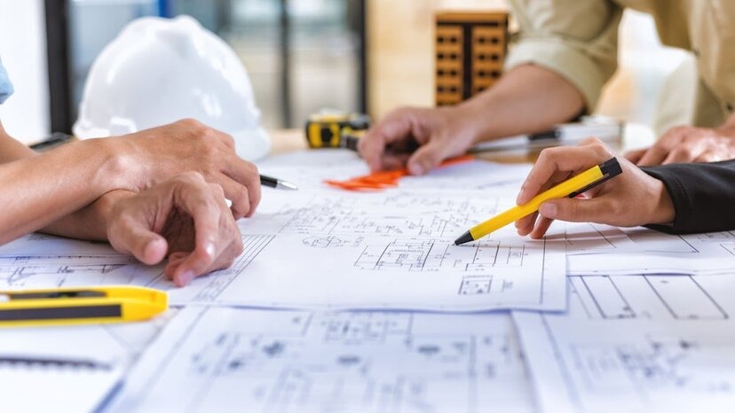 construction workers review blueprints