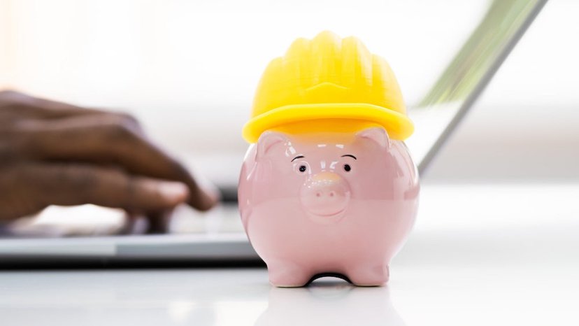 a piggy bank wears a construction hat