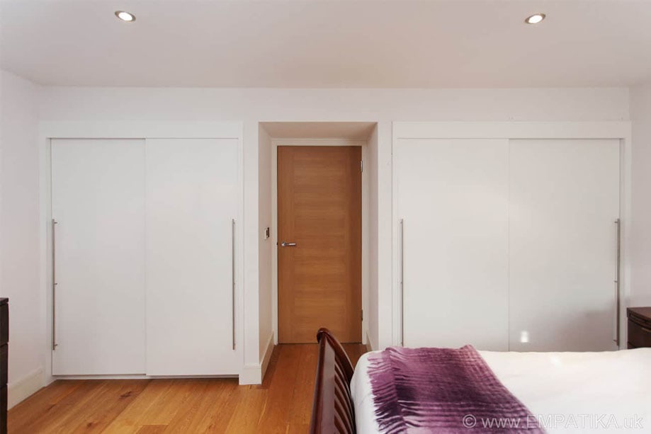 A Pair of Fitted Wardrobes With Sliding Doors