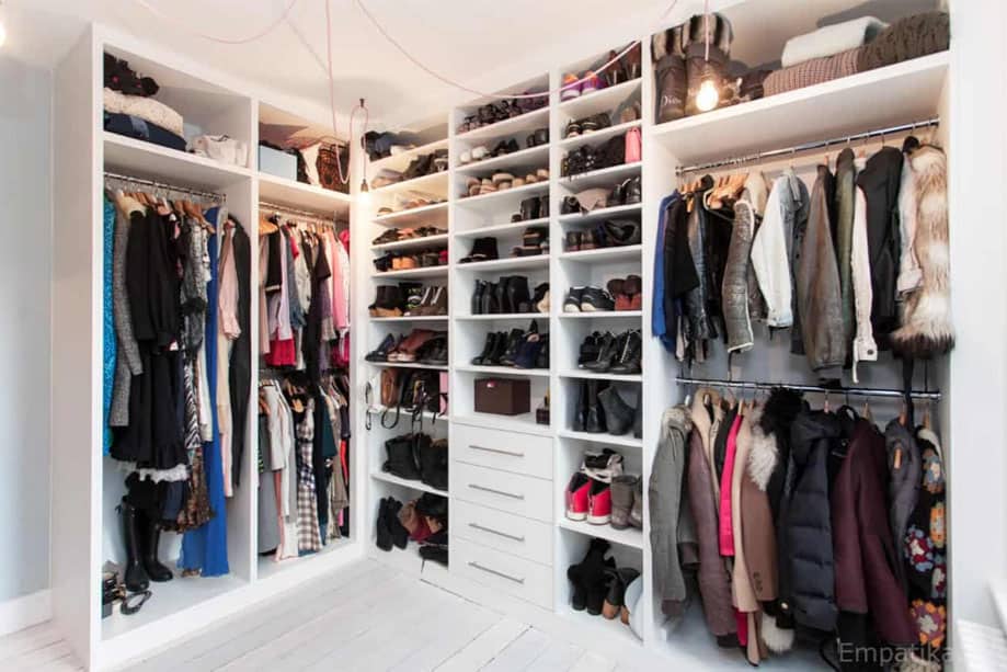 White walk-in wardrobe in two walls witha combination of shelves, drawers, and metal hanging rods