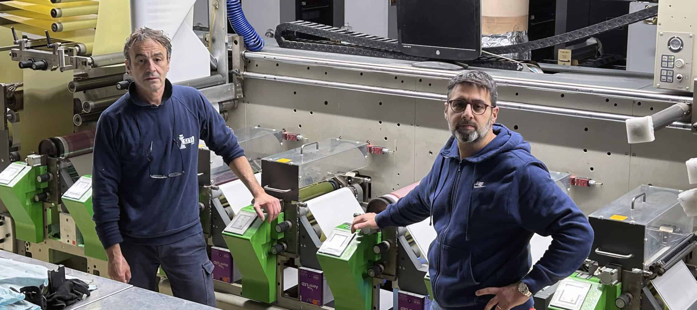 Stefano Masocco y Gianluigi De Blasio con una de sus prensas Bobst, que está instalada con un sistema GEW ArcLED.