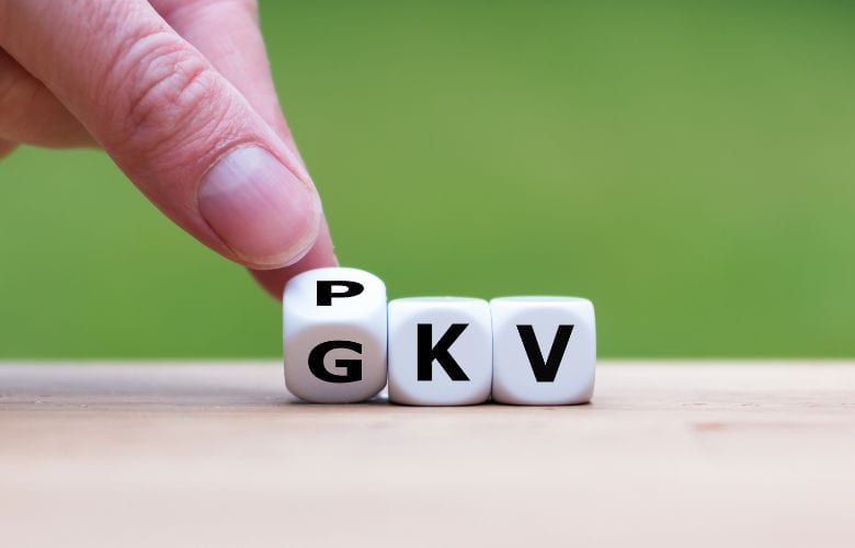 Hand dreht Würfel mit den Buchstaben „GKV“ und „PKV“ als Symbol für die Entscheidung zwischen gesetzlicher und privater Krankenversicherung, speziell für Ärzte.