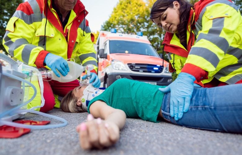 Rettungskräfte versorgen eine verletzte Person am Unfallort – Relevanz der Unfallversicherung für Ärzte.