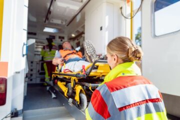 Rettungssanitäter laden einen verletzten Patienten in den Krankenwagen. Anschließend wird POCUS-Ultraschall für eine schnelle Diagnostik genutzt.