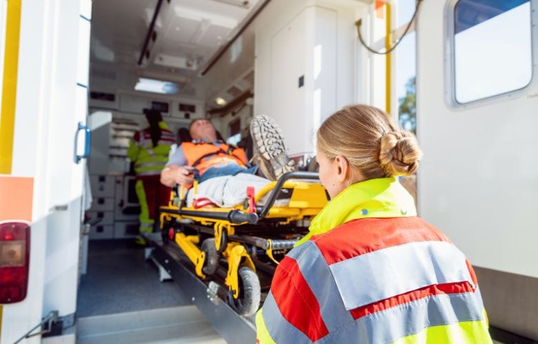 Rettungssanitäter laden einen verletzten Patienten in den Krankenwagen. Anschließend wird POCUS-Ultraschall für eine schnelle Diagnostik genutzt.