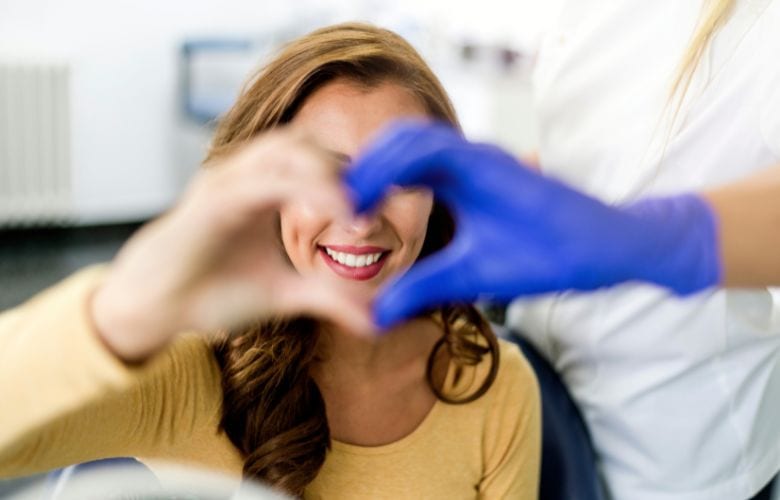 Patientin formt gemeinsam mit medizinischer Fachkraft ein Herzsymbol als Zeichen für patientenzentrierte Versorgung in der Praxis.