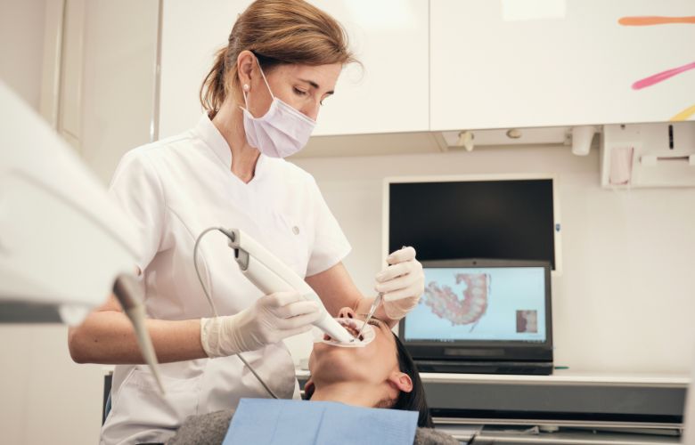 Eine Zahnärztin erstellt einen digitalen Zahnabdruck mit einem Intraoralscanner.